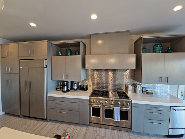 kitchen featuring gray cabinetry, backsplash, custom exhaust hood, and high quality appliances