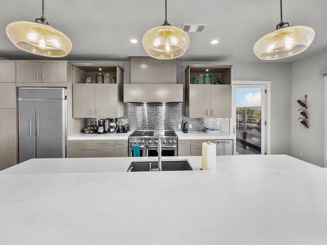 kitchen with decorative backsplash, wall chimney range hood, hanging light fixtures, and high quality appliances