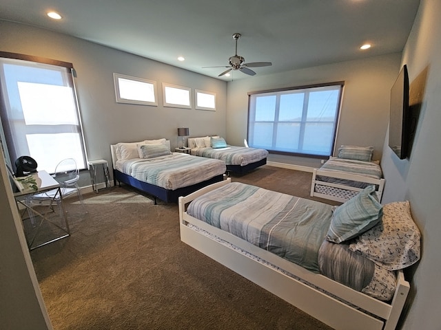 bedroom with ceiling fan and dark colored carpet