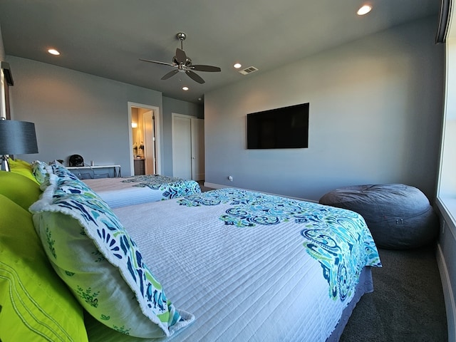 carpeted bedroom with ceiling fan and ensuite bathroom