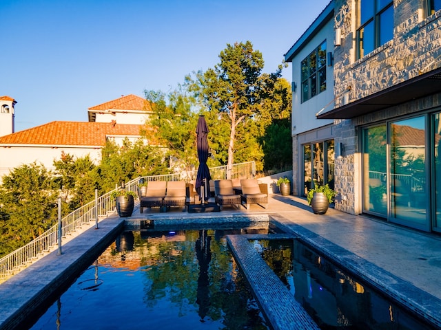 view of pool with an outdoor living space and a patio