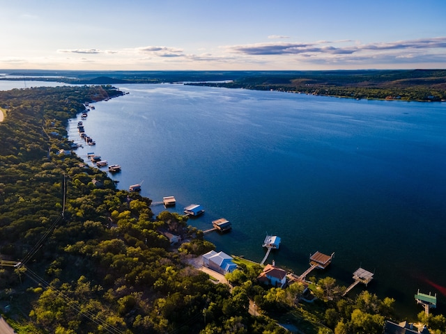 aerial view at dusk featuring a water view