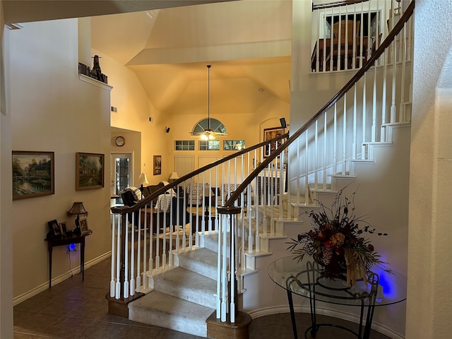 staircase featuring high vaulted ceiling and tile patterned floors