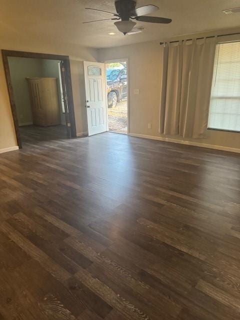 empty room with ceiling fan and dark hardwood / wood-style flooring