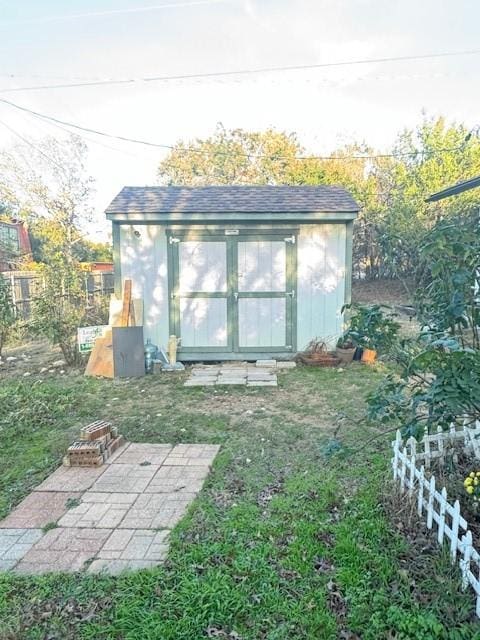 view of outdoor structure with an outdoor fire pit and a lawn