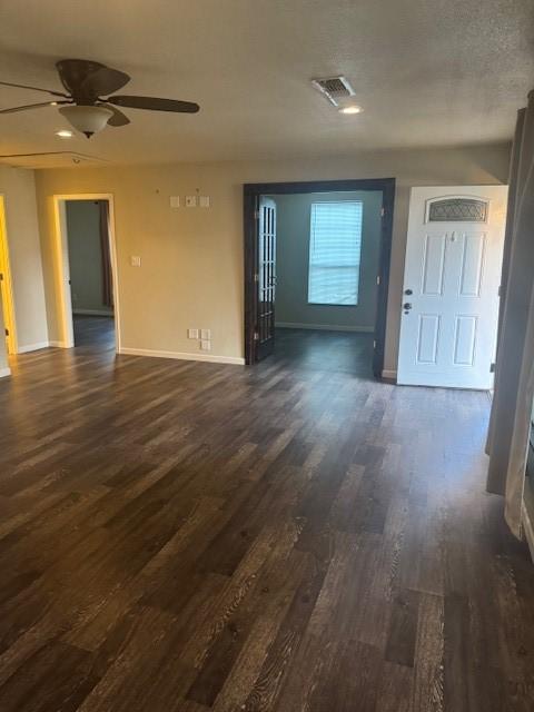 unfurnished living room with ceiling fan and dark hardwood / wood-style flooring