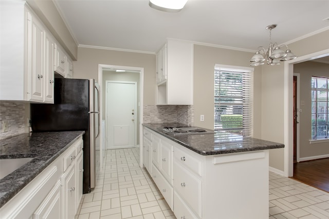 kitchen featuring appliances with stainless steel finishes, hanging light fixtures, white cabinets, backsplash, and ornamental molding