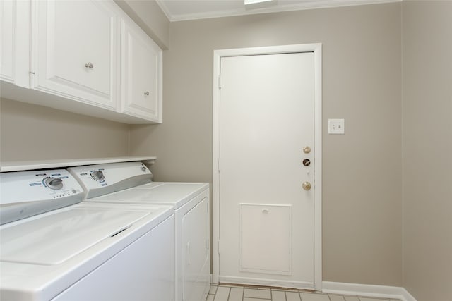 laundry area with crown molding, washer and dryer, and cabinets