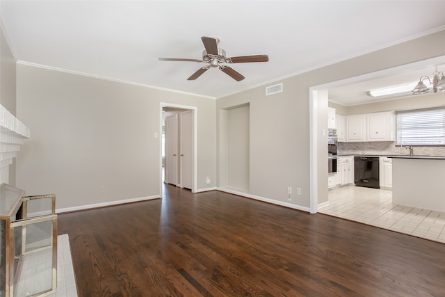 unfurnished living room featuring a brick fireplace, ceiling fan with notable chandelier, light wood-type flooring, and crown molding