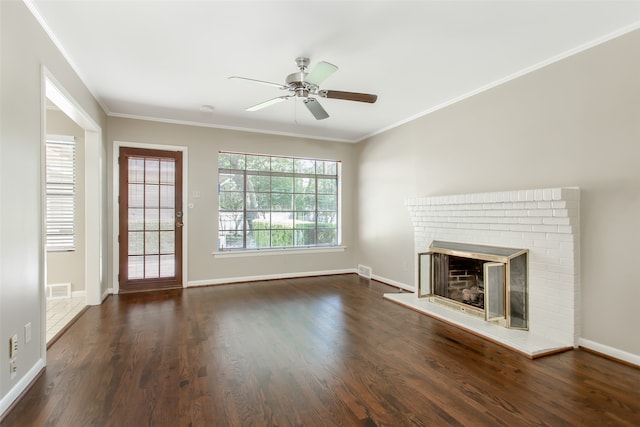 unfurnished living room with ornamental molding, dark hardwood / wood-style flooring, ceiling fan, and a brick fireplace