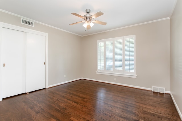 unfurnished bedroom featuring a closet, ceiling fan, crown molding, and dark hardwood / wood-style flooring