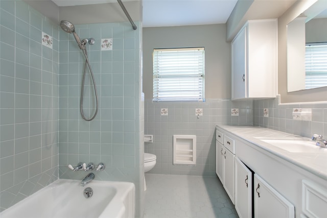 full bathroom featuring tile walls, vanity, tiled shower / bath combo, tile patterned flooring, and toilet