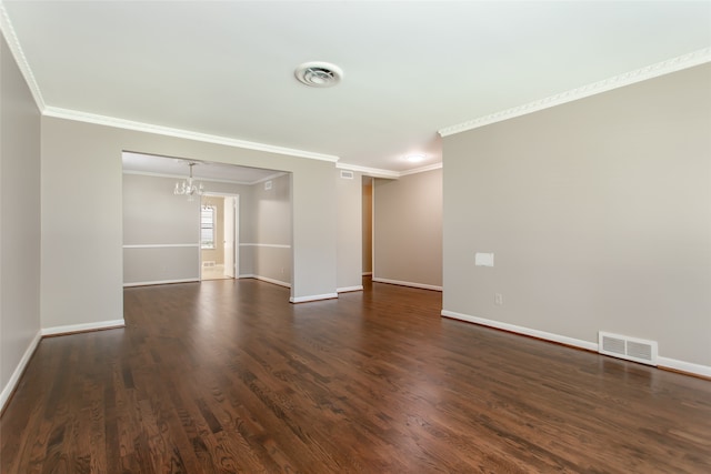 spare room featuring an inviting chandelier, crown molding, and dark wood-type flooring