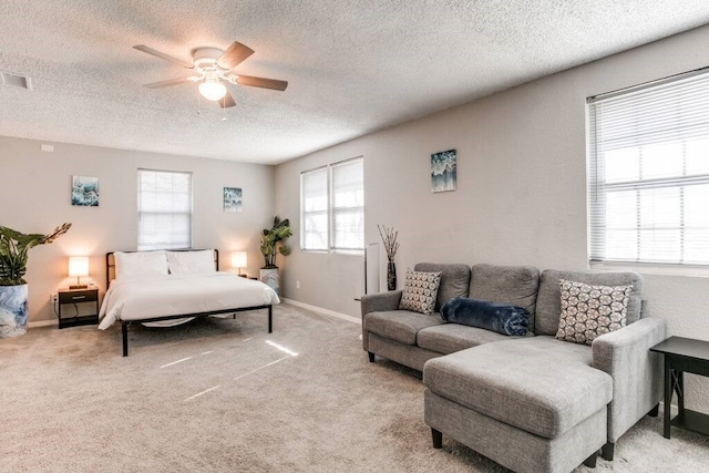 bedroom featuring ceiling fan, light carpet, and multiple windows