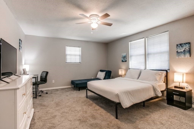 carpeted bedroom with ceiling fan and a textured ceiling