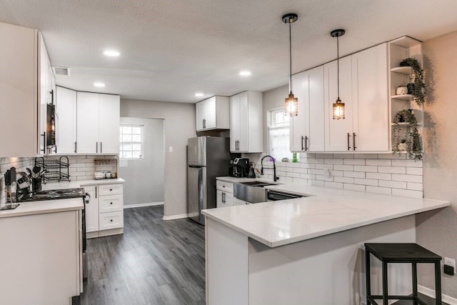 kitchen with kitchen peninsula, white cabinetry, stainless steel appliances, and plenty of natural light