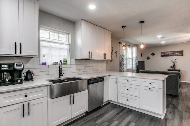 kitchen with white cabinetry, kitchen peninsula, dishwasher, pendant lighting, and sink