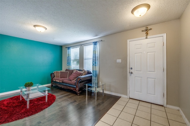 entryway with light hardwood / wood-style floors and a textured ceiling