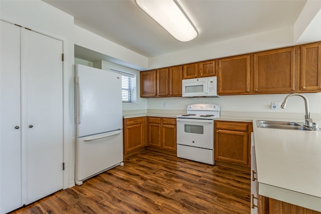 kitchen featuring sink, dark hardwood / wood-style flooring, and white appliances