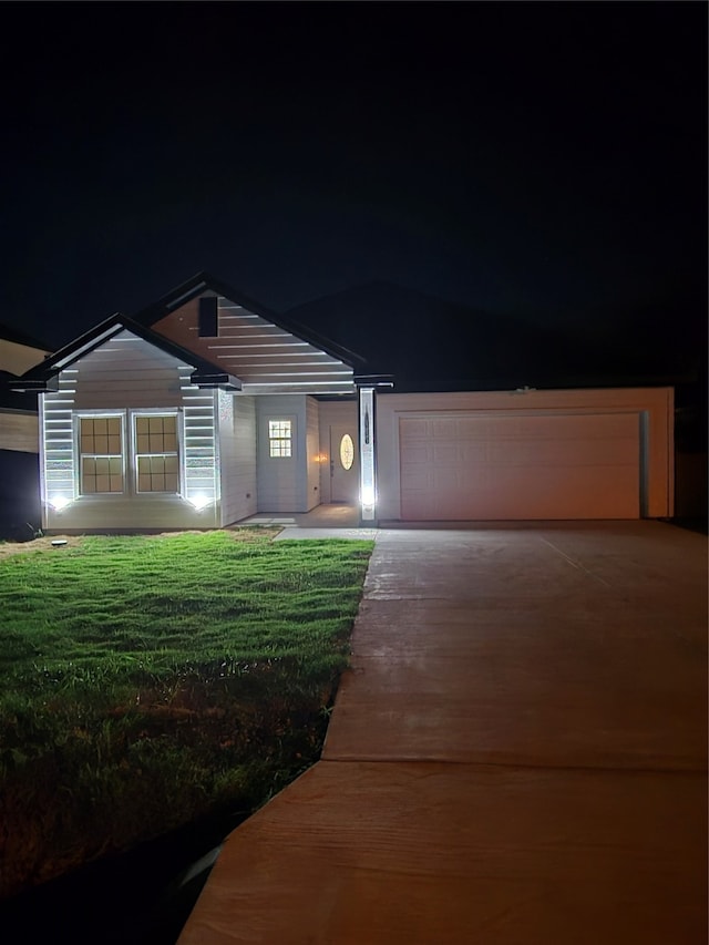 view of front of property with a garage and a yard