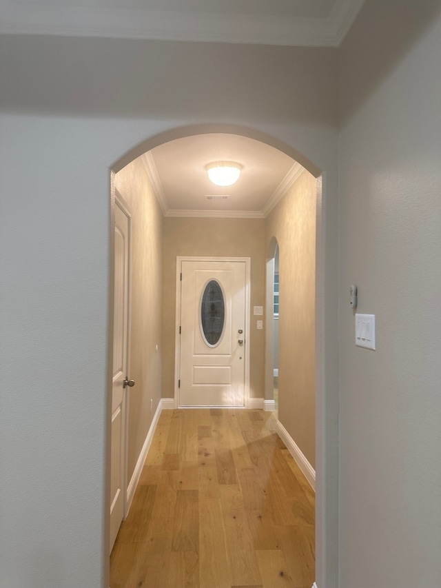 corridor with light hardwood / wood-style flooring and crown molding