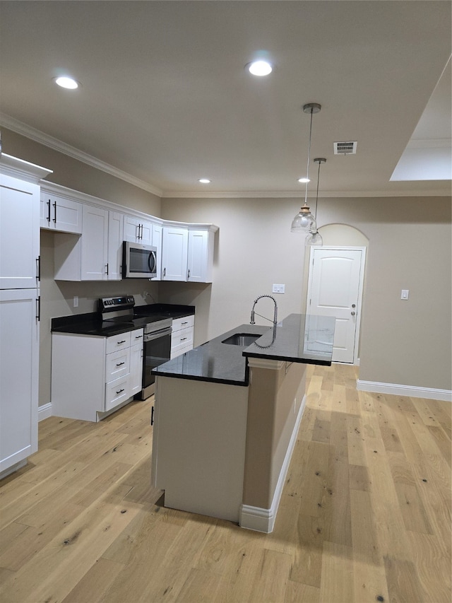 kitchen with appliances with stainless steel finishes, white cabinetry, pendant lighting, light hardwood / wood-style flooring, and sink