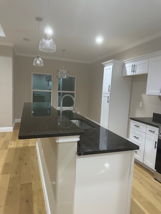 kitchen featuring pendant lighting, light wood-type flooring, white cabinetry, and a kitchen island