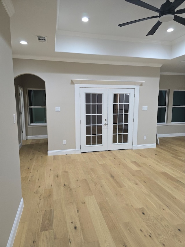 unfurnished living room with crown molding, light hardwood / wood-style floors, ceiling fan, and french doors