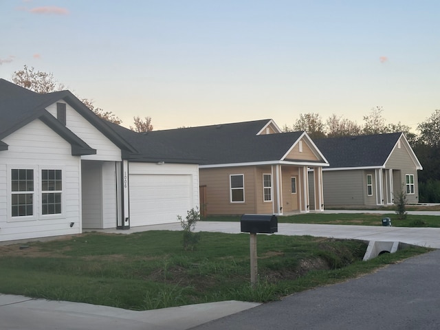 ranch-style home featuring a lawn and a garage