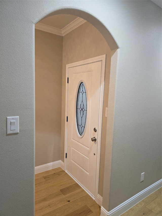 entrance foyer featuring crown molding and light hardwood / wood-style floors