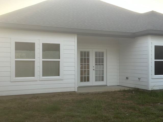 view of property exterior with french doors and a yard