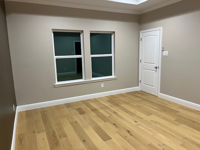 unfurnished room featuring wood-type flooring and ornamental molding