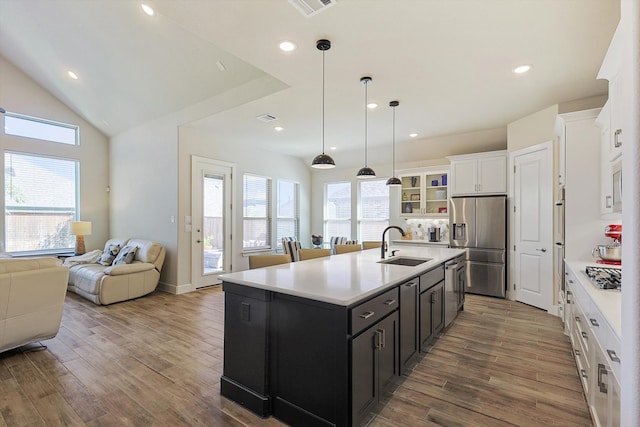 kitchen with a wealth of natural light, white cabinetry, an island with sink, and appliances with stainless steel finishes