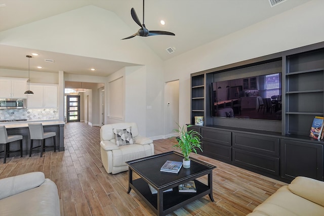 living room featuring light wood-type flooring, high vaulted ceiling, and ceiling fan