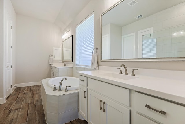 bathroom featuring a tub, vanity, and wood-type flooring