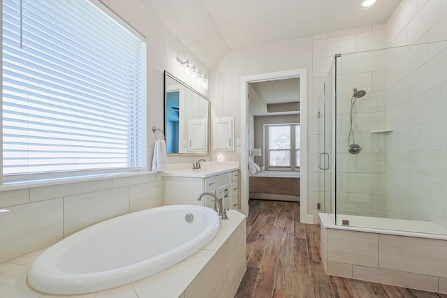 bathroom with hardwood / wood-style floors, vanity, and shower with separate bathtub