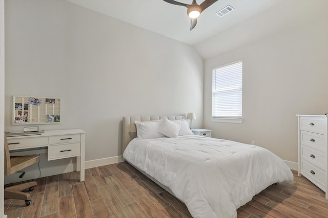 bedroom with ceiling fan, lofted ceiling, and hardwood / wood-style flooring