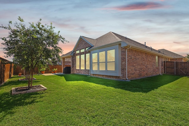 property exterior at dusk featuring a yard