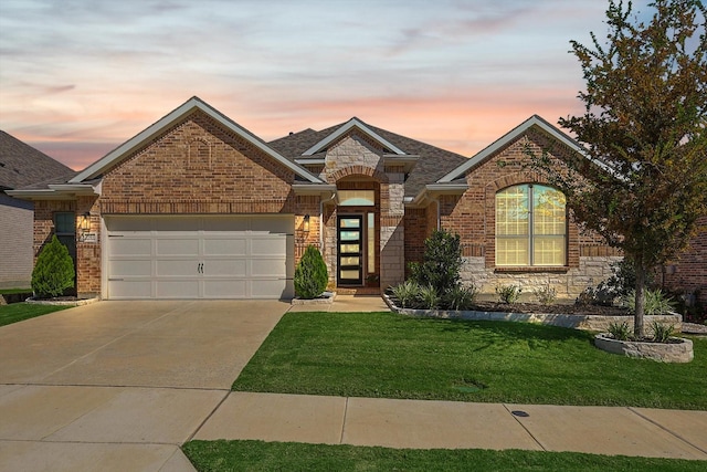 view of front of home with a yard and a garage