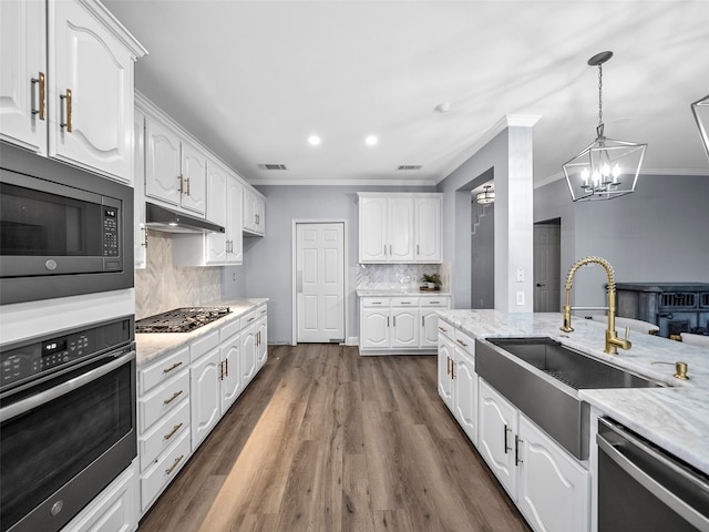 kitchen with dark hardwood / wood-style flooring, white cabinets, appliances with stainless steel finishes, and sink