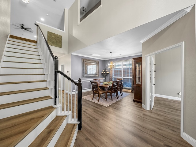 interior space featuring ceiling fan with notable chandelier, ornamental molding, and hardwood / wood-style floors