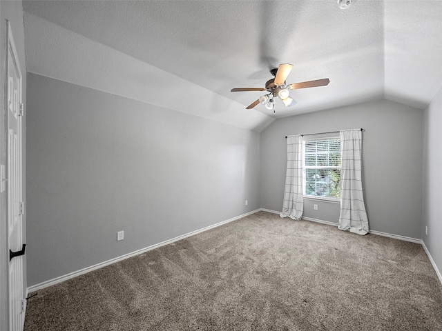 empty room with carpet, vaulted ceiling, and ceiling fan