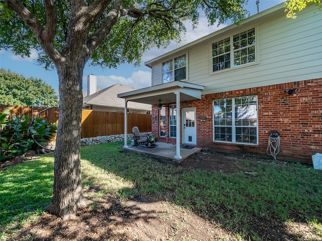 back of house featuring a lawn and a patio area