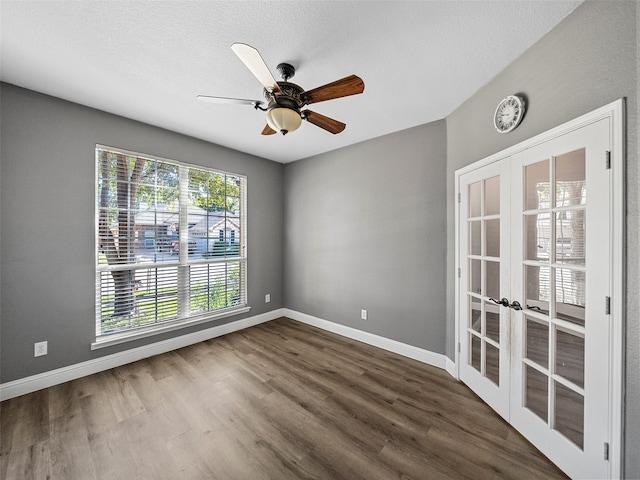 spare room with a textured ceiling, dark hardwood / wood-style floors, ceiling fan, and french doors