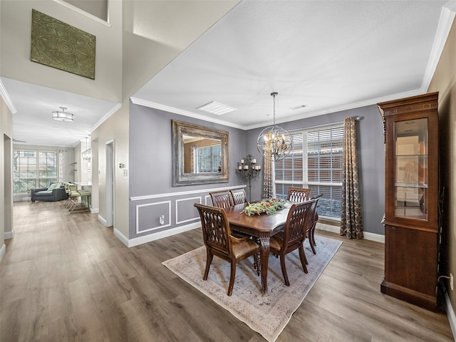 dining room with an inviting chandelier, crown molding, and dark wood-type flooring