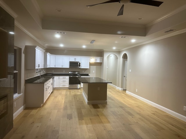 kitchen with light wood-type flooring, white cabinets, appliances with stainless steel finishes, crown molding, and ceiling fan