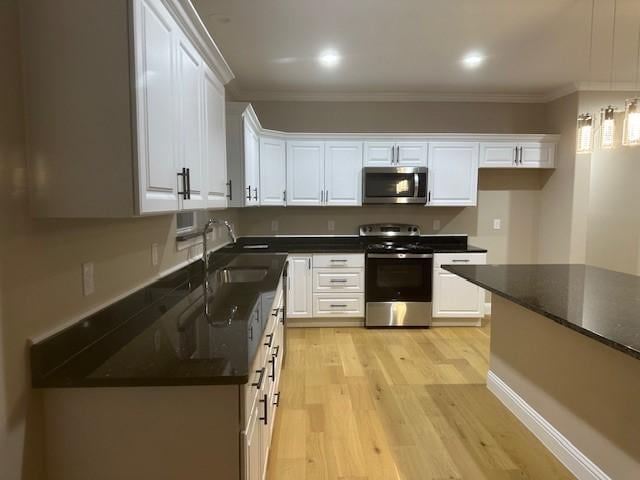 1008 S Preston St, Ennis, TX 75119 - kitchen with appliances with stainless steel finishes, dark countertops, white cabinets, and crown molding