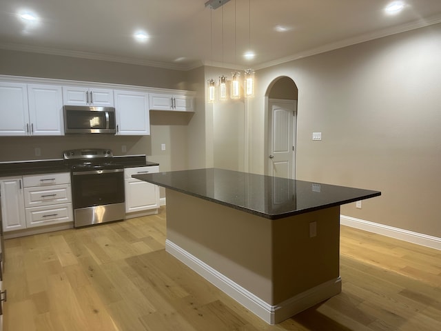 kitchen featuring hanging light fixtures, appliances with stainless steel finishes, a center island, and white cabinetry