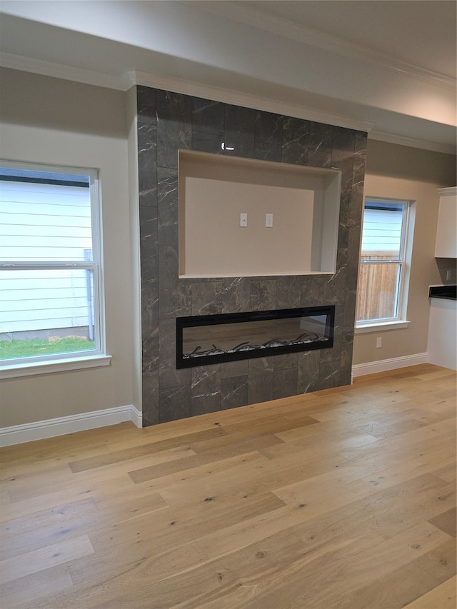 interior details featuring ornamental molding, a large fireplace, and hardwood / wood-style floors