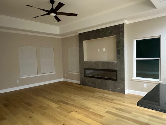 1008 S Preston St, Ennis, TX 75119 - unfurnished living room featuring a high end fireplace, a raised ceiling, crown molding, wood finished floors, and ceiling fan